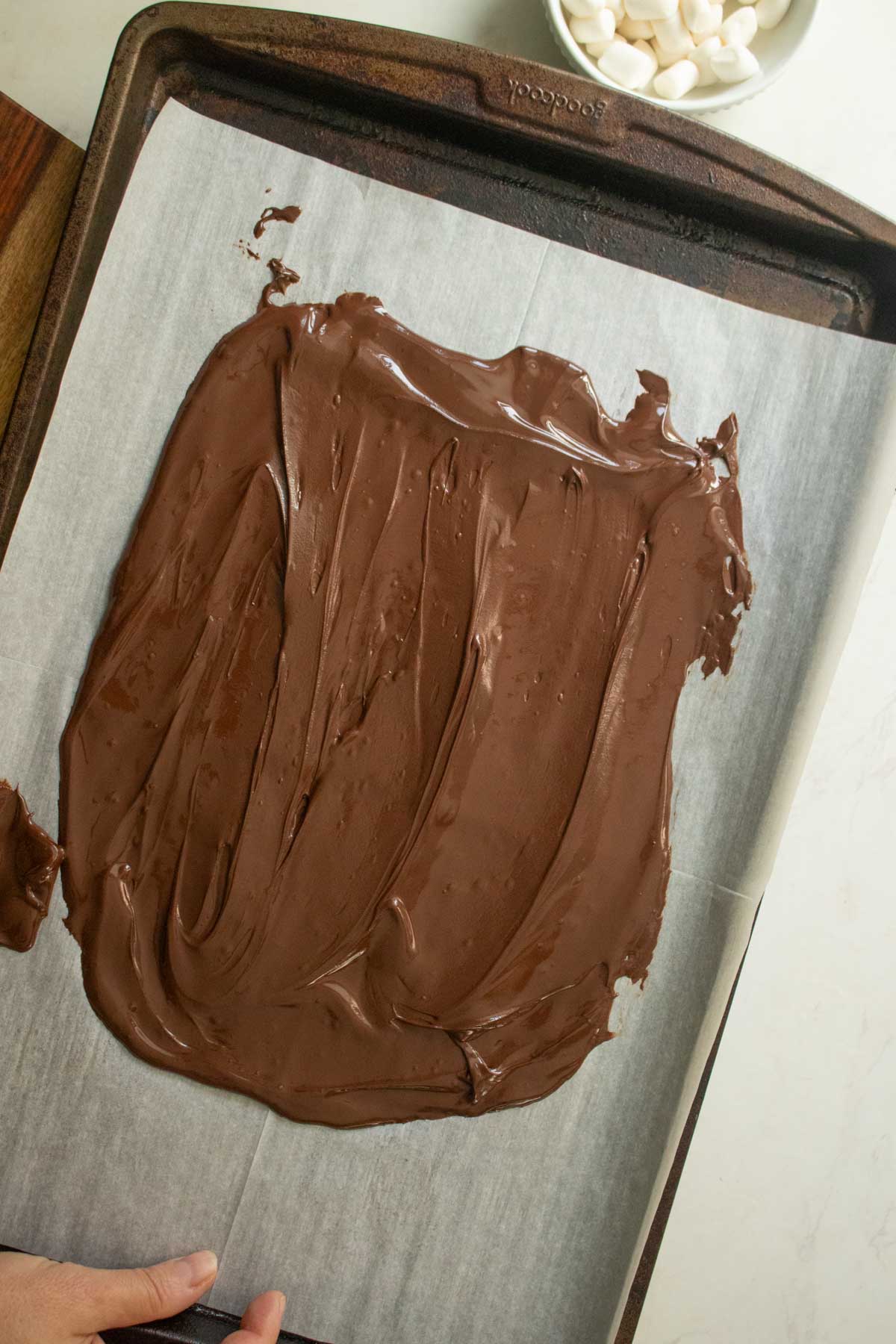 chocolate chips on the baking sheet after melting and spreading