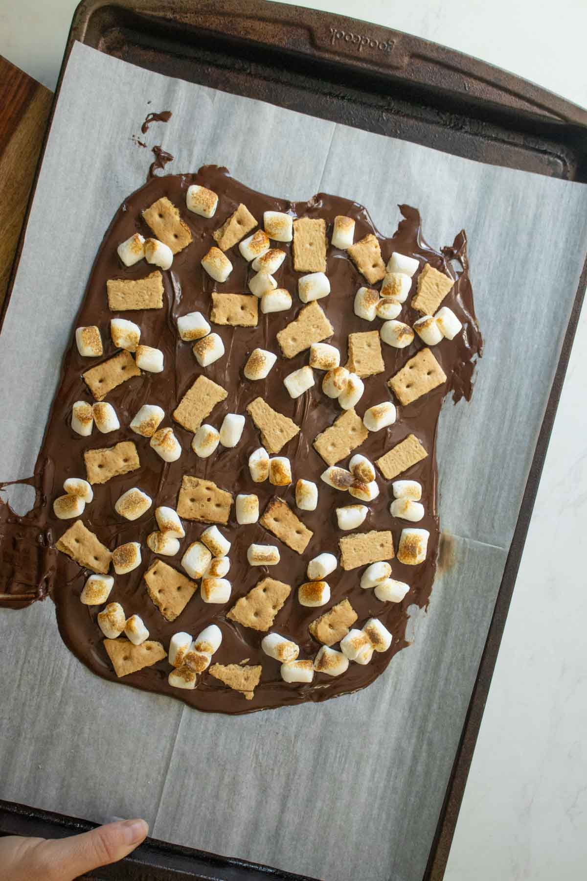 s'mores bark after adding the marshmallows and graham crackers and toasting the marshmallows