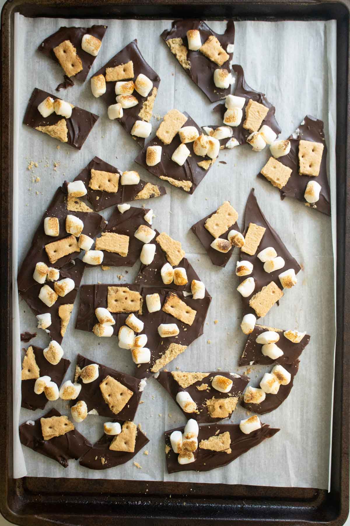 s'mores bark on the baking sheet after breaking it into pieces